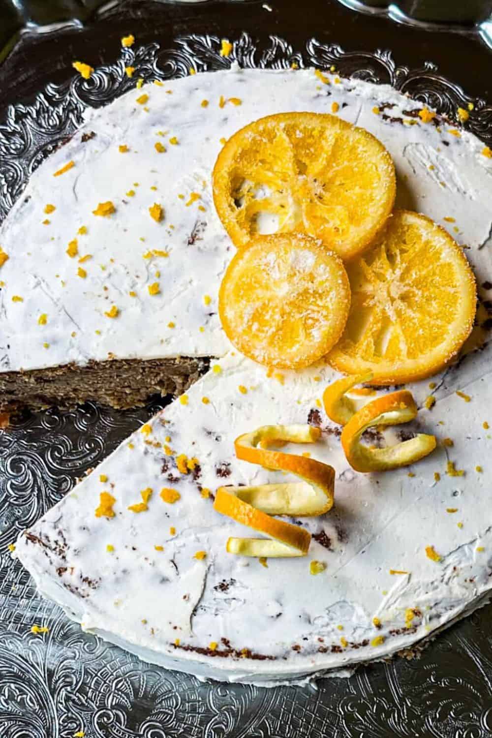 Lemon cake with lemon slices and citrus peel decoration on a silver tray.