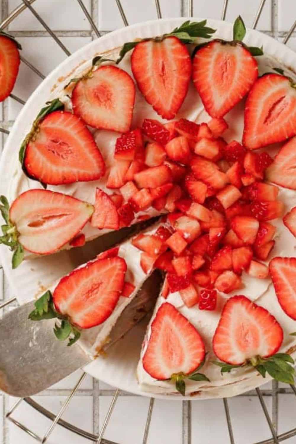 Fresh strawberry cake with sliced strawberries and folding technique.