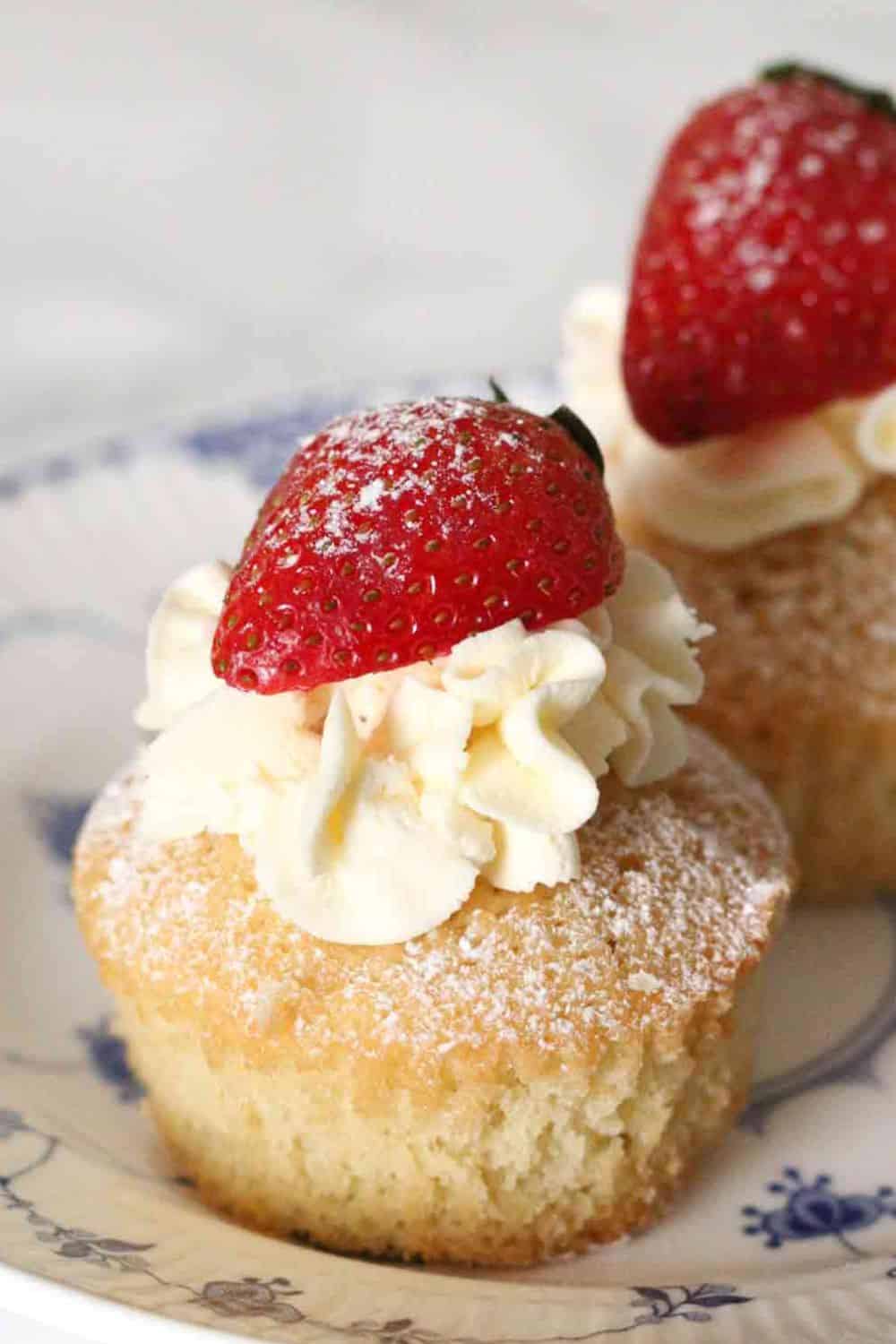 Mini strawberry shortcakes topped with fresh strawberries and whipped cream.