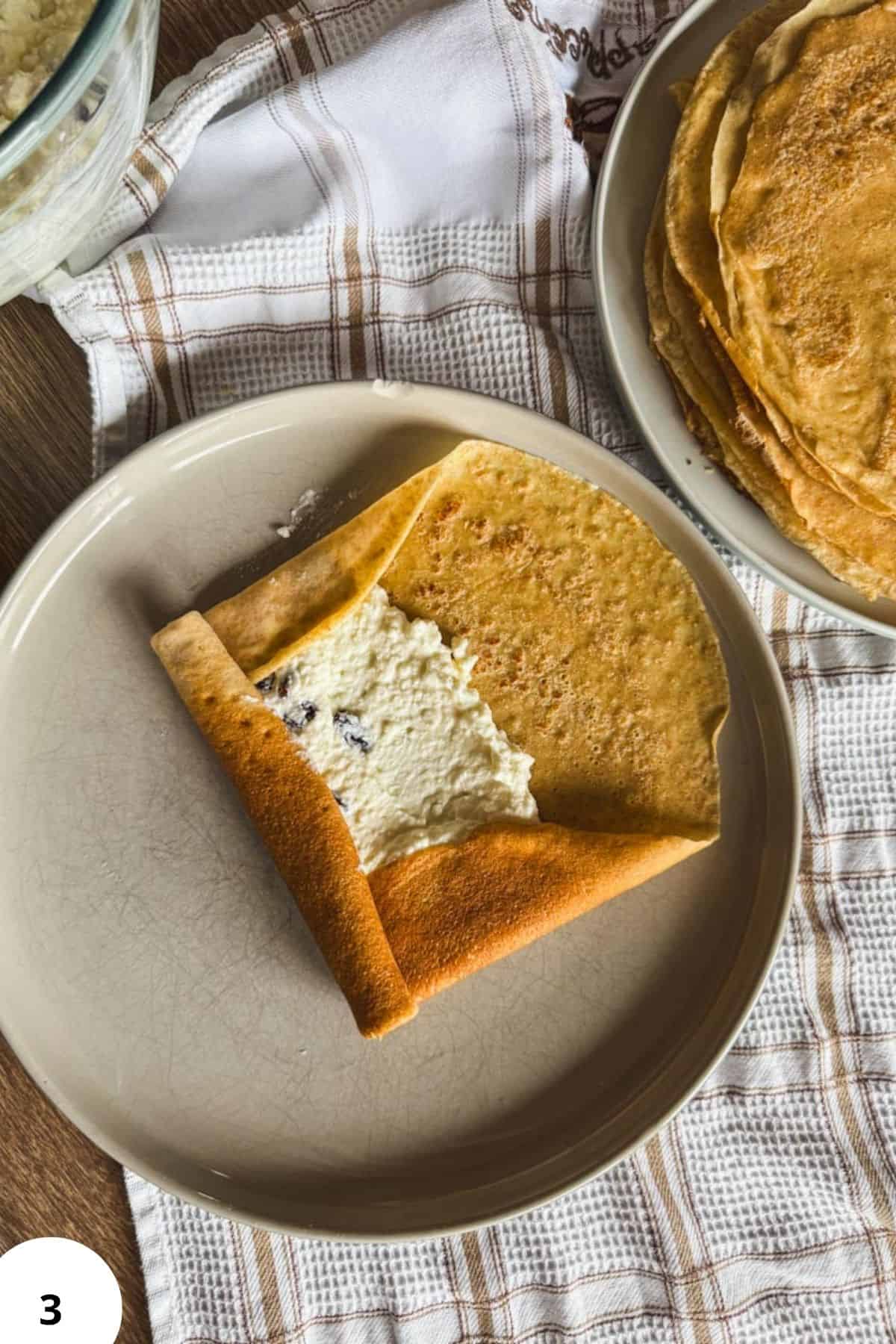 Baked crepe with sweet cheese filling on a plate, ready to serve.