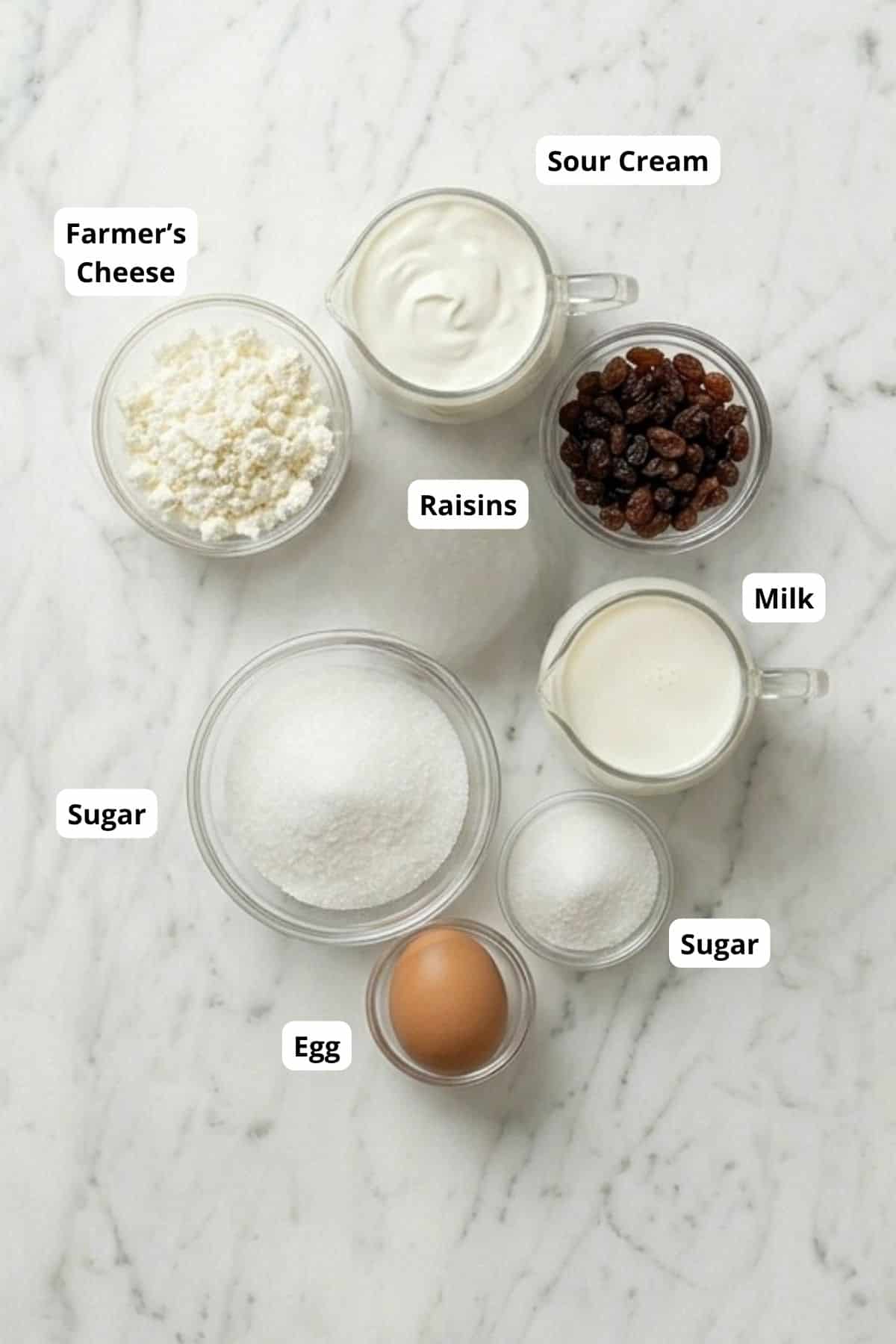 Ingredients for baked crepes with sweet cheese, including farmer's cheese, sour cream, raisins, milk.