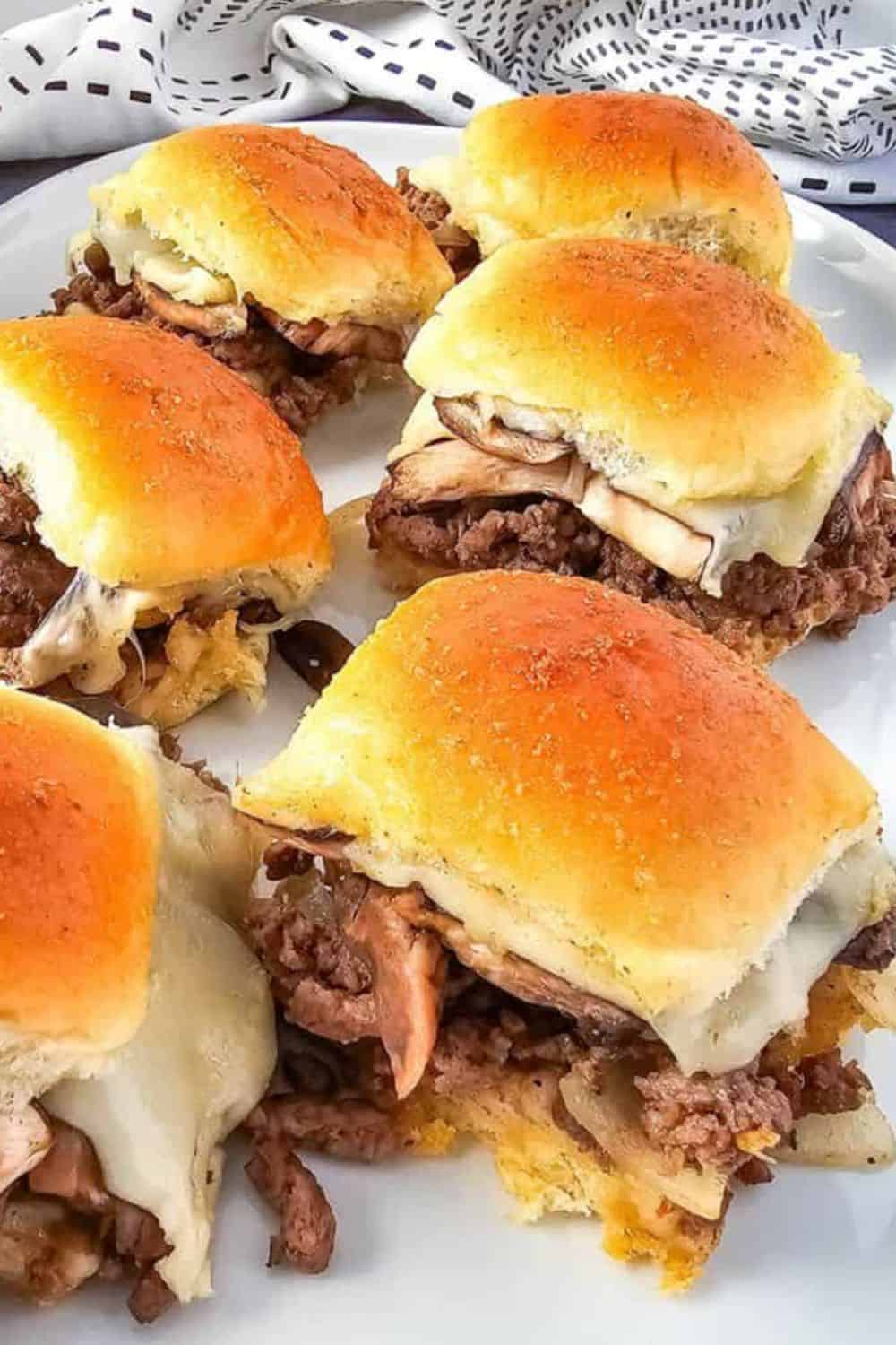 Delicious cheeseburger sliders with beef, cheese, and buns on a white plate.