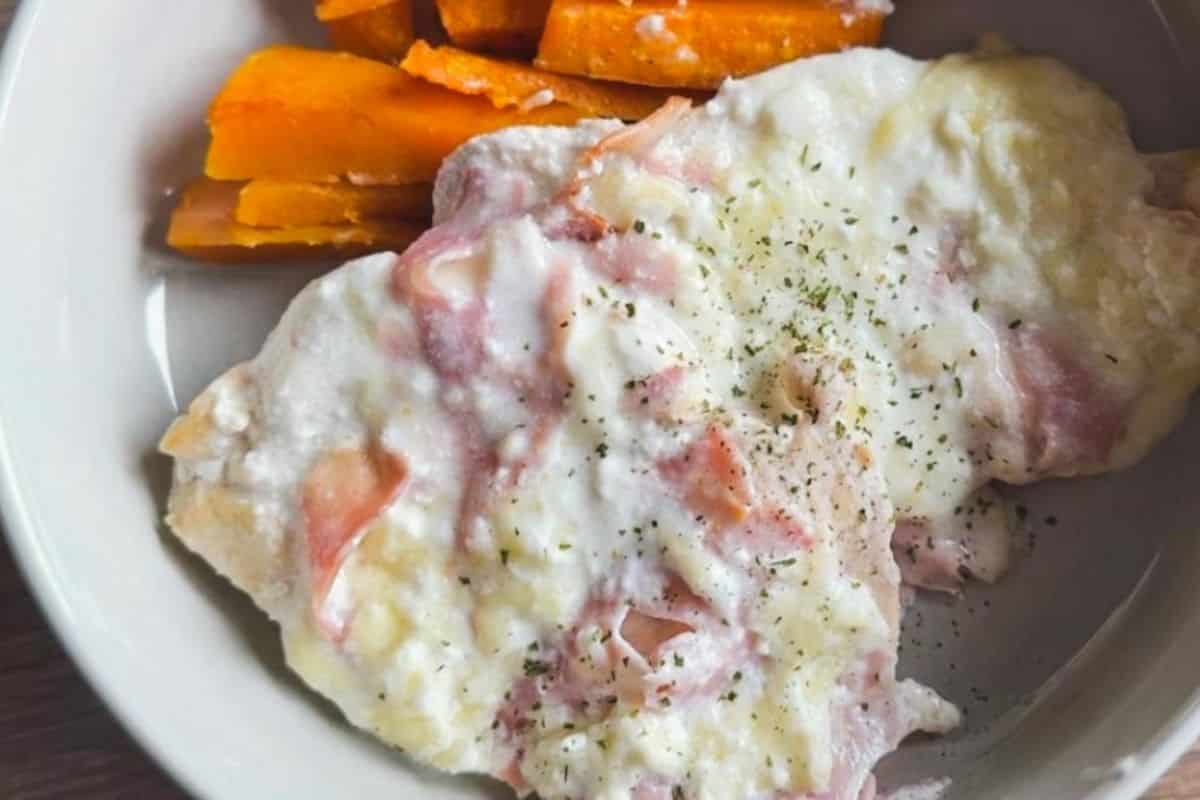 Hearty breakfast with eggs, ham, and cheese in a white bowl.