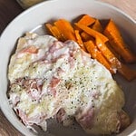 Delicious ham and cheese omelette with sweet potato fries on a white plate.