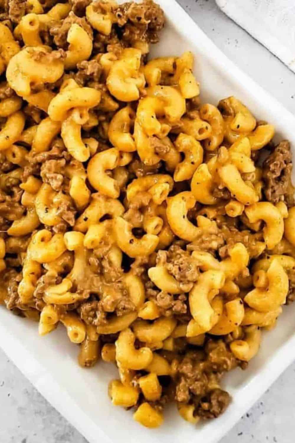 Cheesy ground beef macaroni casserole in a white dish.