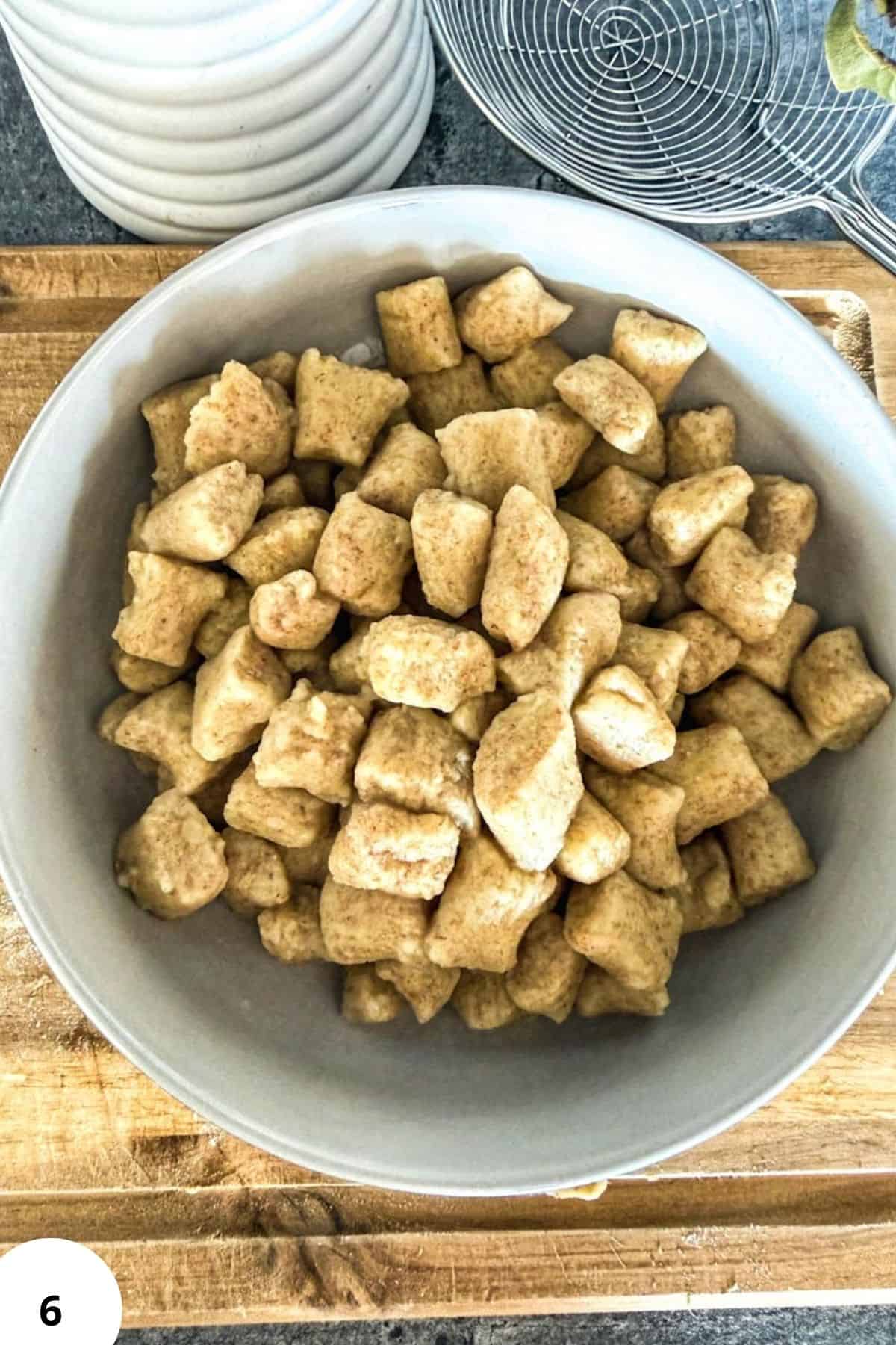 Homemade gnocchi made with fresh-milled flour on a wooden surface.