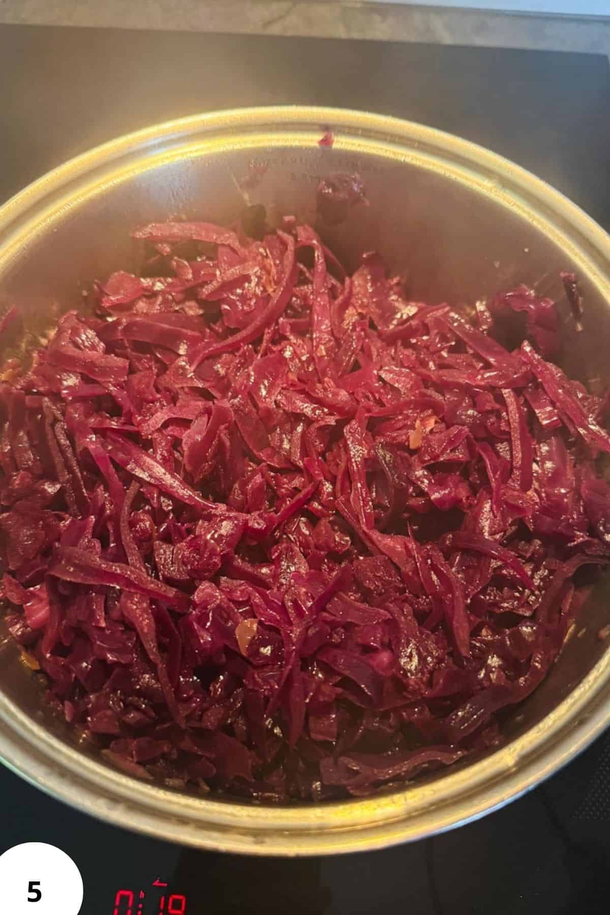 Steamed red cabbage with apple slices, perfect for traditional German dishes.
