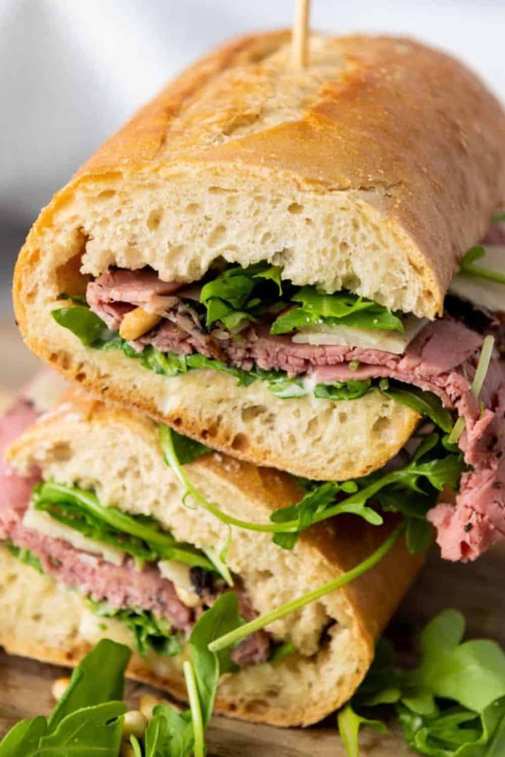 Delicious roast beef sandwich with greens in a crusty baguette.