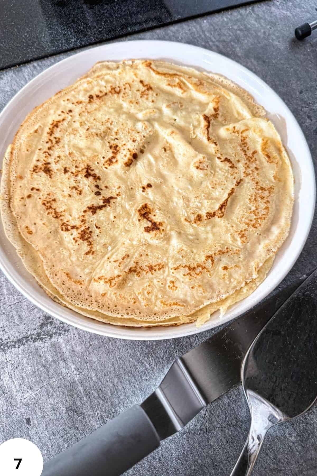 Close-up of sourdough crepes cooked with stretch and fold technique in a white bowl.