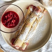 Delicious sourdough palatschinken served with fresh berry compote, dusted with powdered sugar for a.