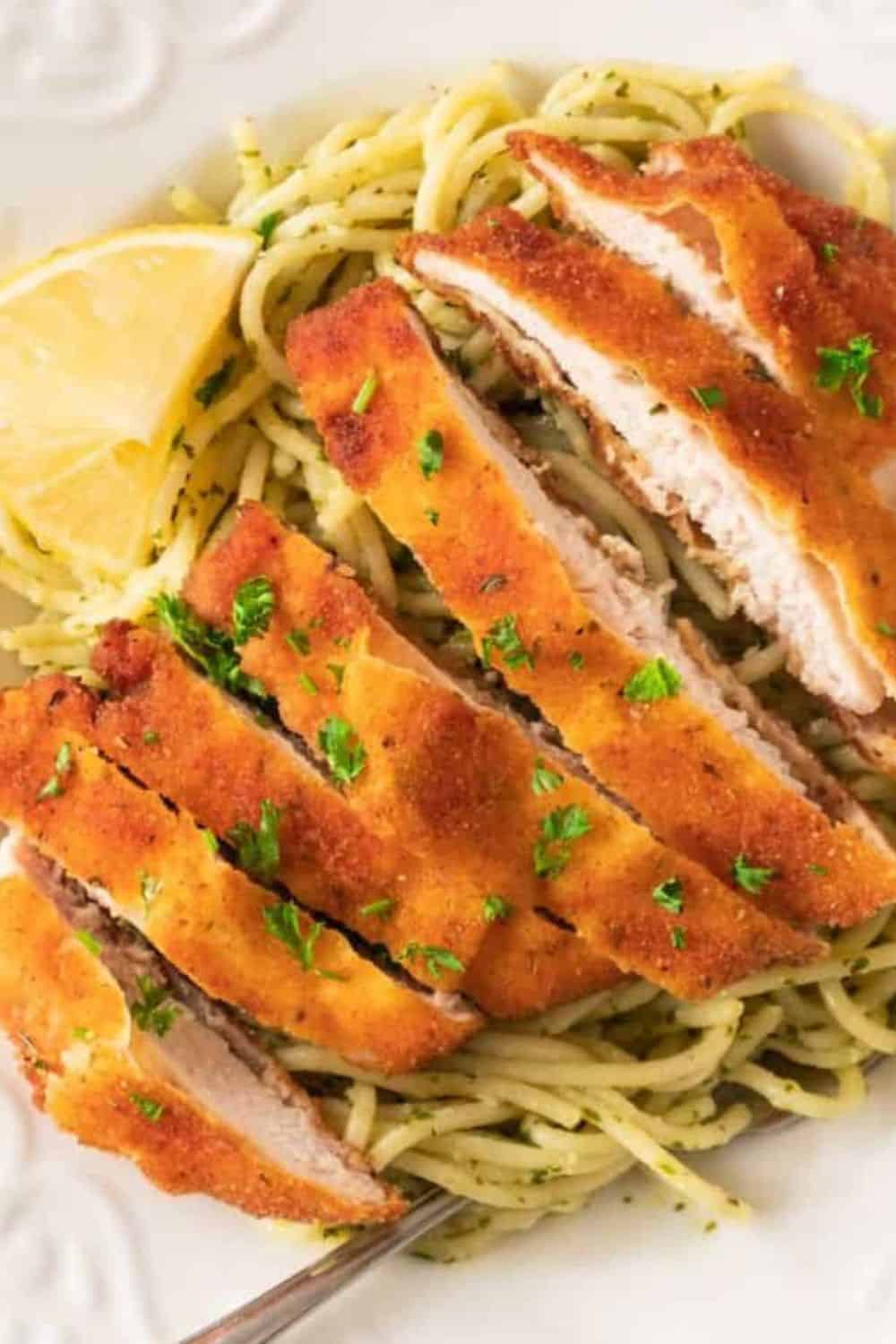 Crispy chicken schnitzel served with lemon and pasta, perfect quick meal for busy days.