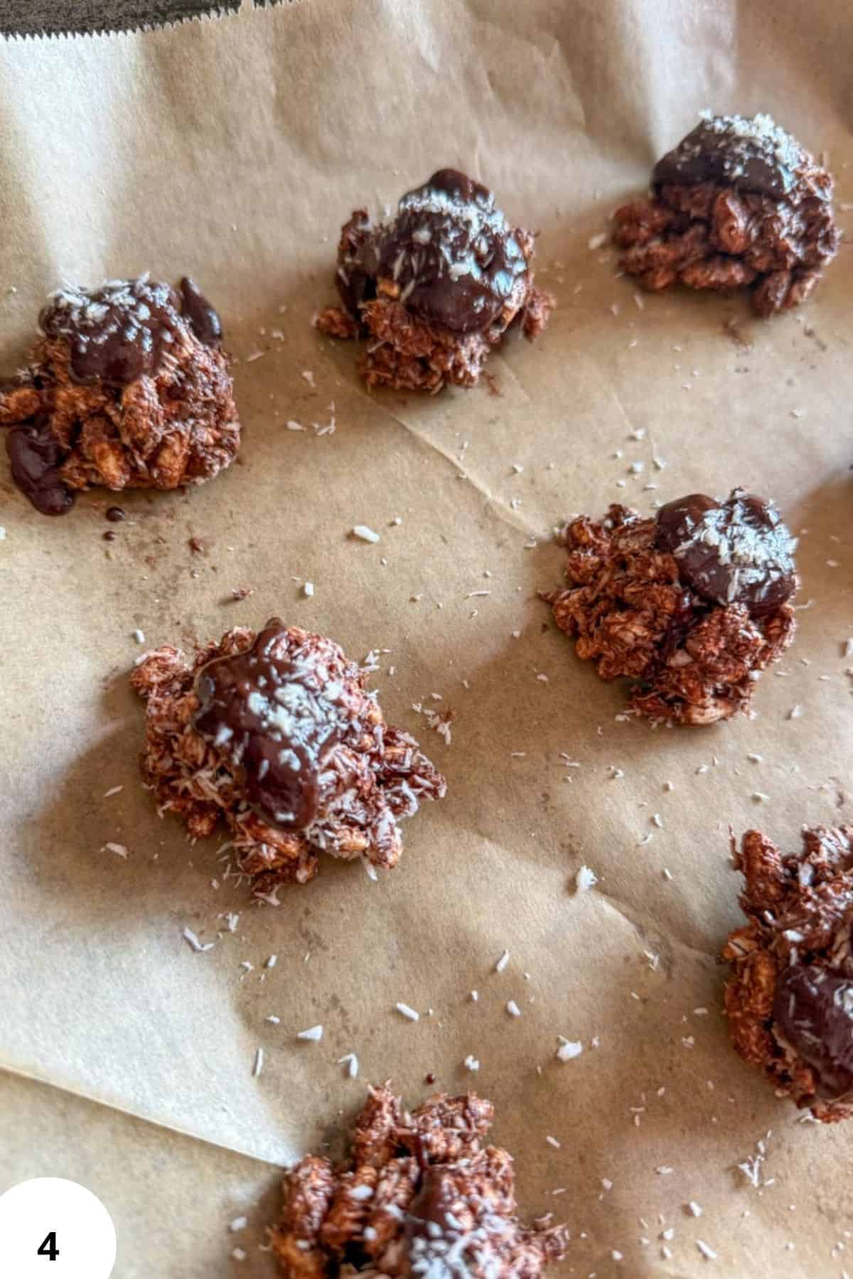 Chocolate coconut cookies with sea salt on brown parchment paper.