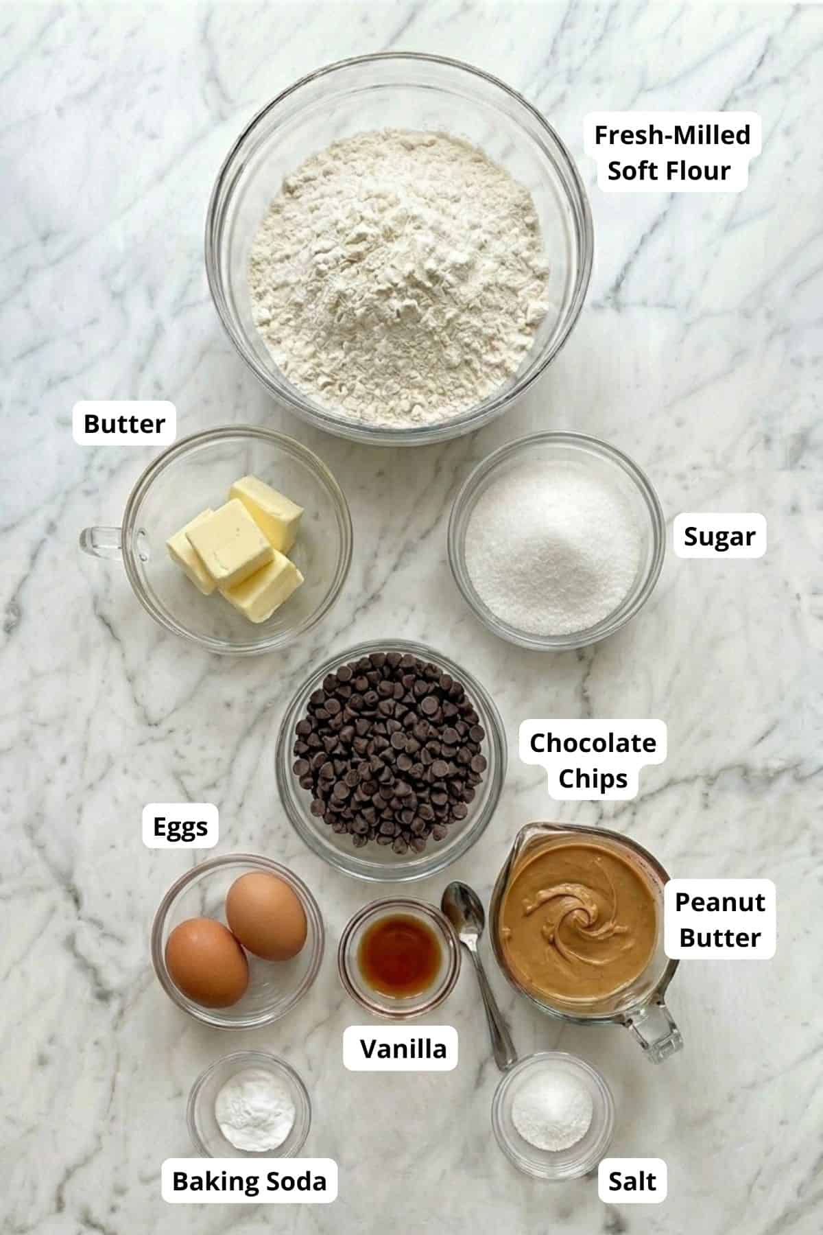 Ingredients for homemade peanut butter chocolate chip cookies on marble surface.