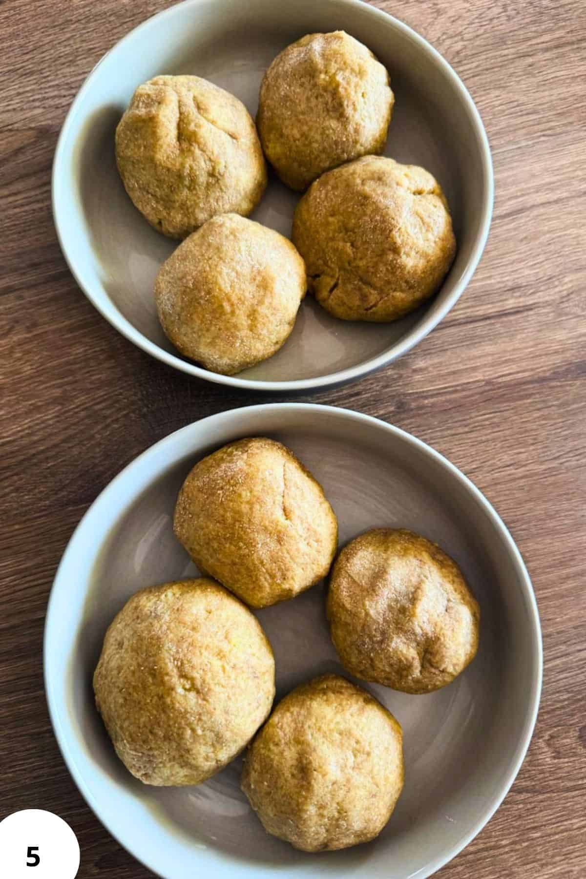 Freshly baked bread balls on white plates, rustic wooden background.