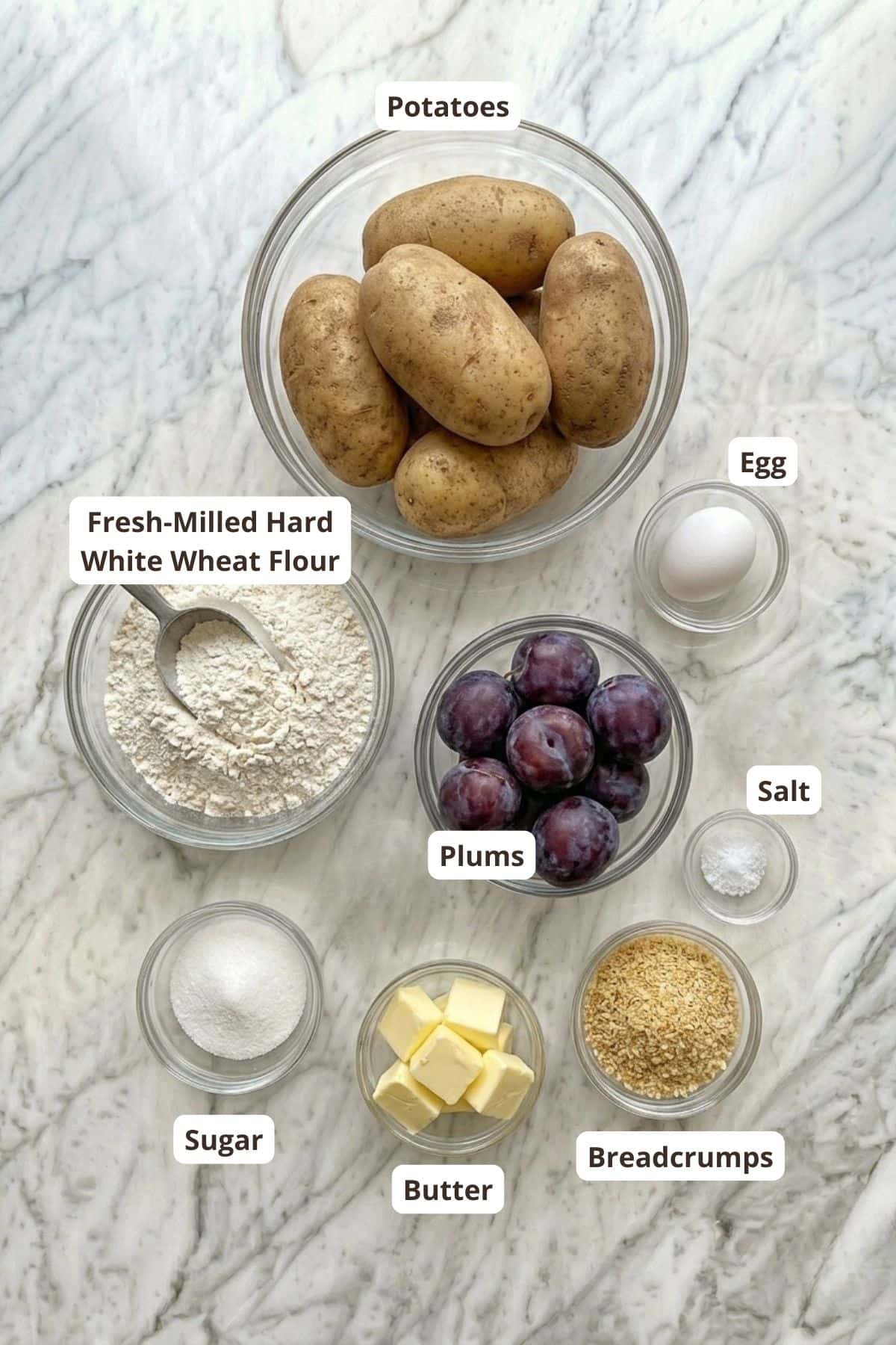 Fresh potatoes, wheat flour, plums, and baking ingredients for homemade bread.