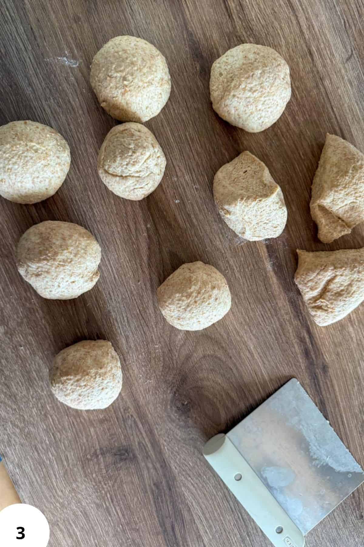 Sourdough dough balls and chunks on wooden surface for baking.