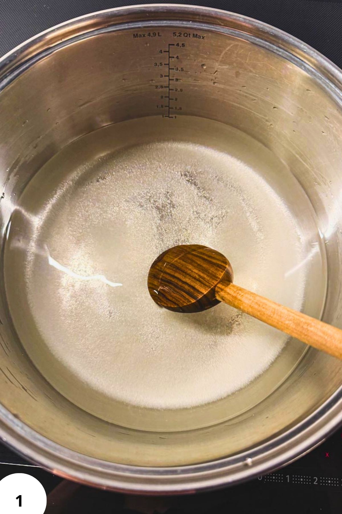 Dough in a pot with a wooden spoon for stretch and fold bread technique.