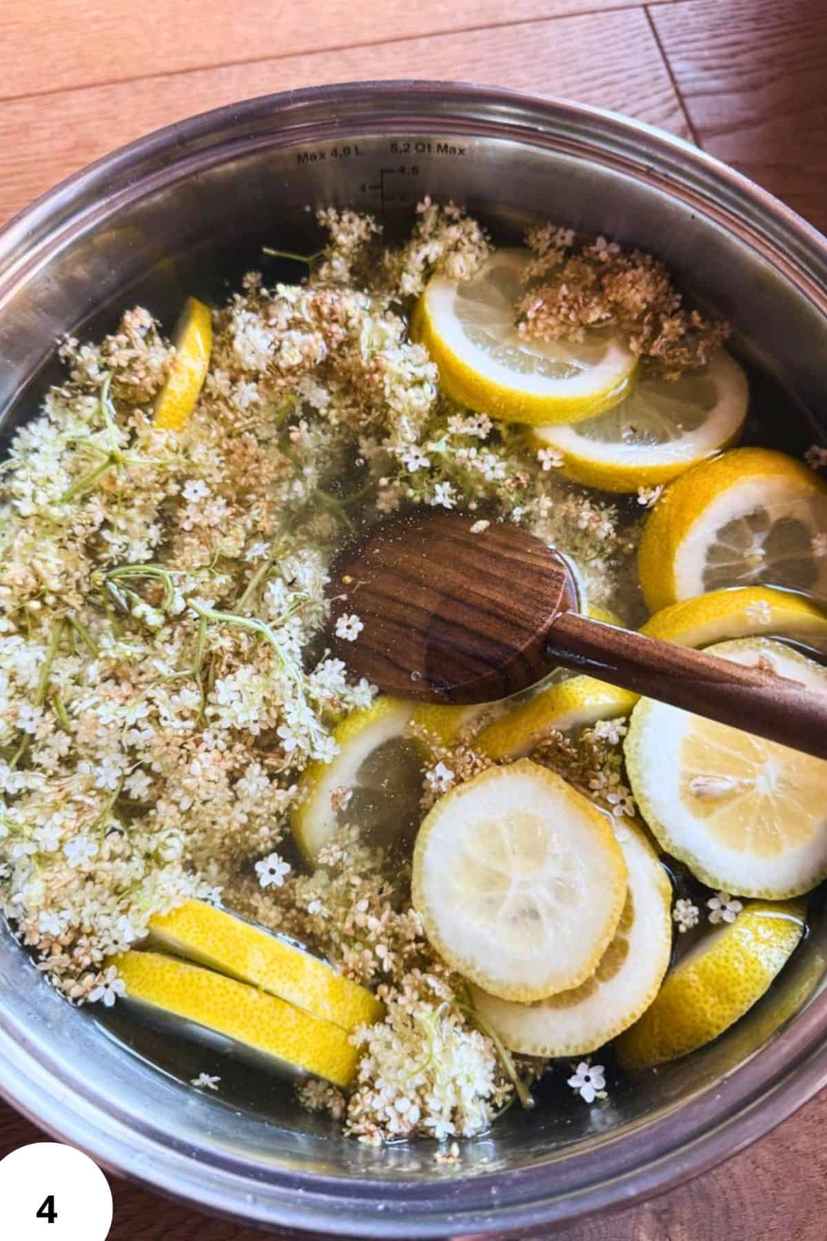 Lemon and elderflower infusion in water with fresh slices and flowers.