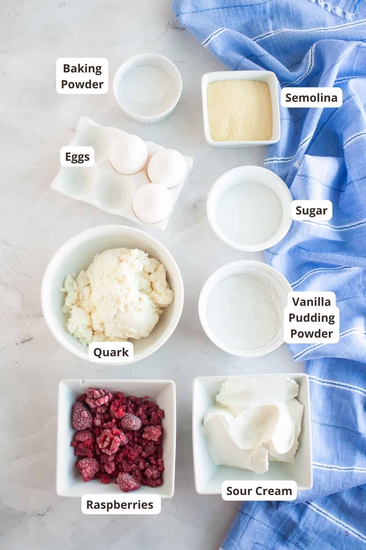Assorted baking ingredients including eggs, sugar, raspberries, and sour cream for pastry making.