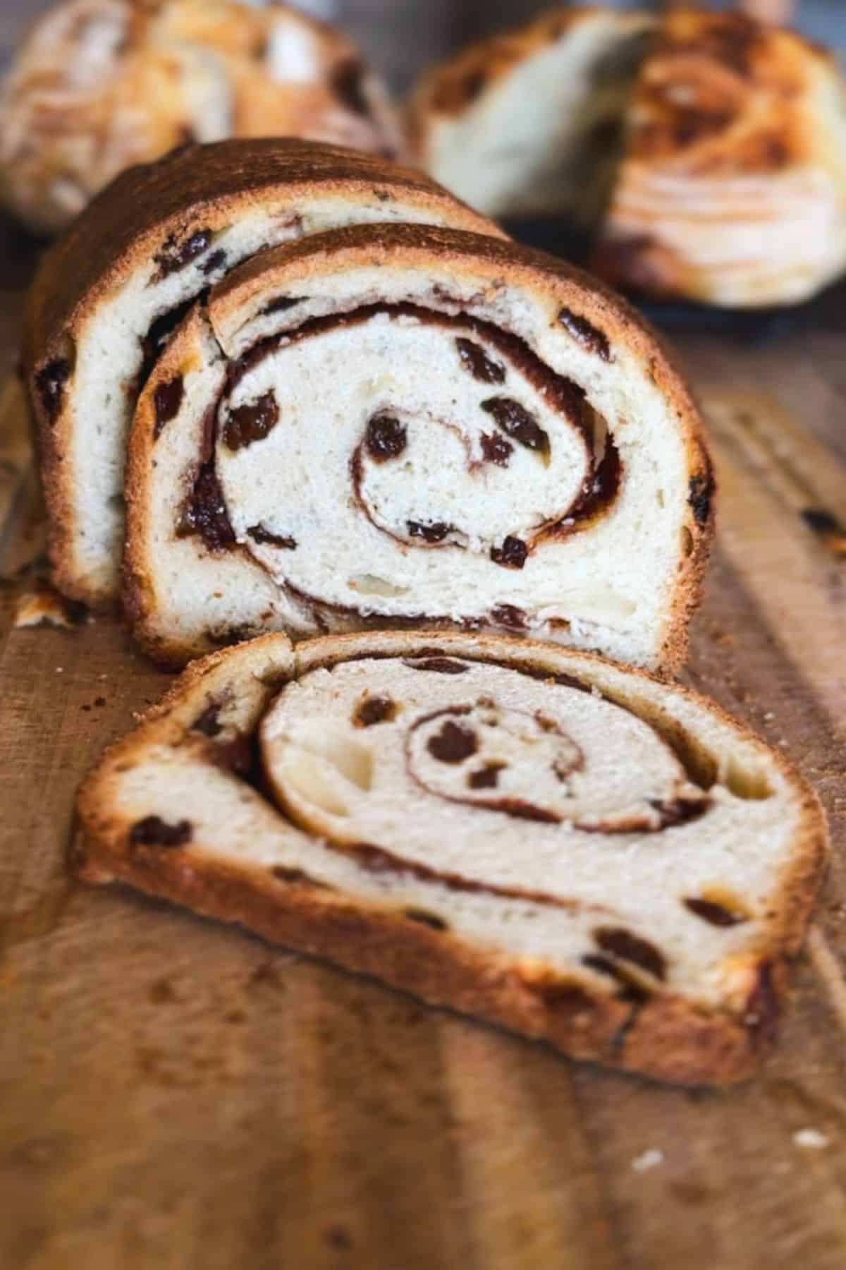 Freshly baked cinnamon swirl bread with chocolate chips, sliced to show the spiral pattern.