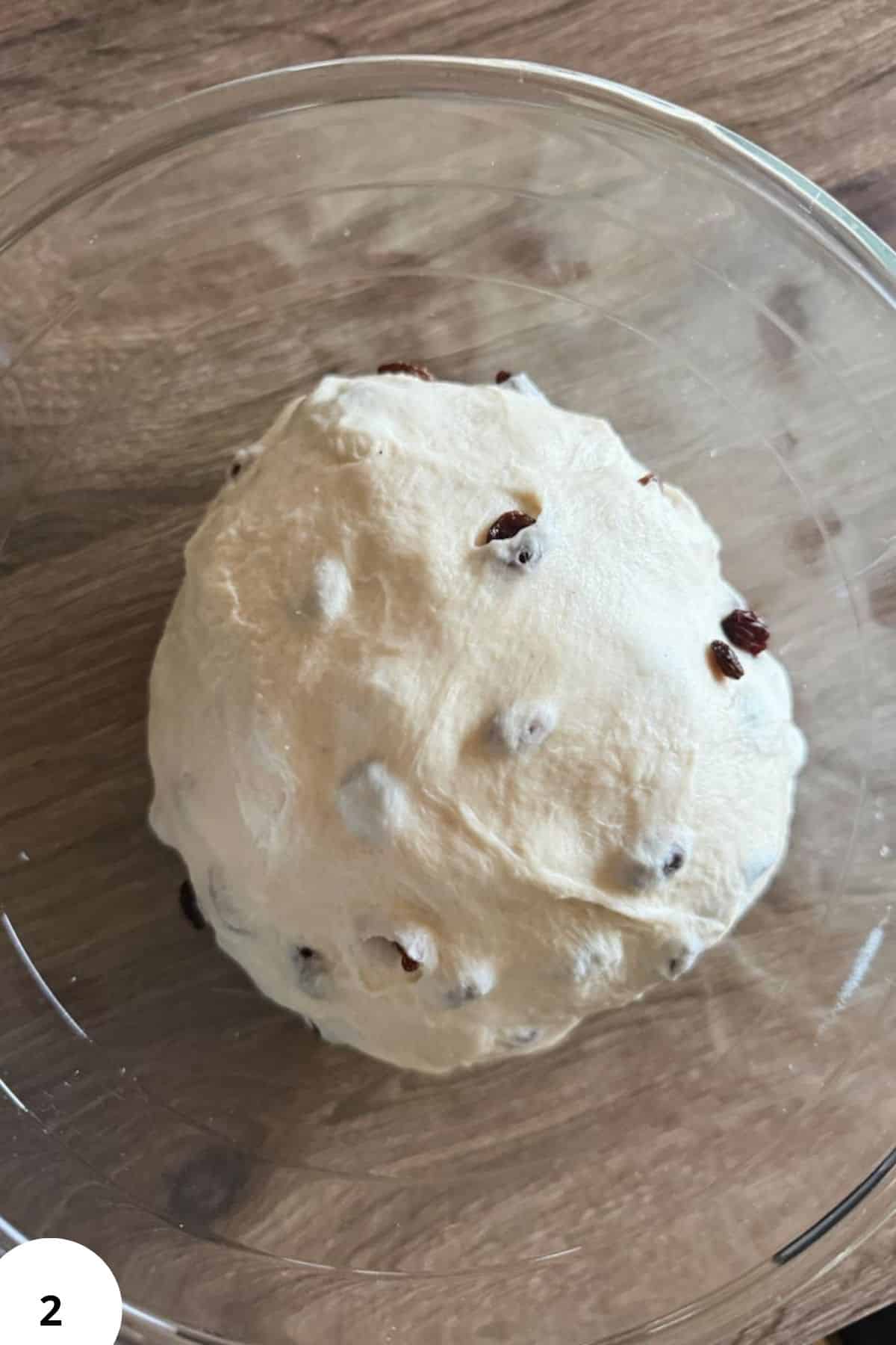 Dough undergoing stretch and fold technique in a glass bowl for bread baking.
