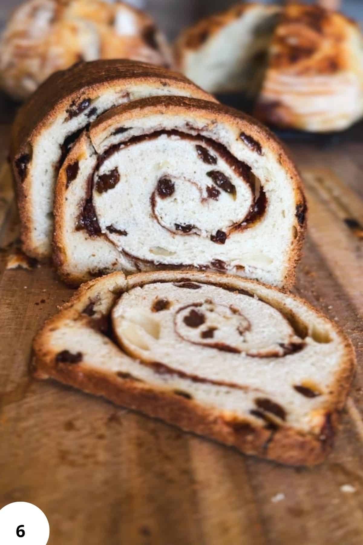 Freshly baked cinnamon swirl bread with chocolate chips, sliced to show the spiral pattern.