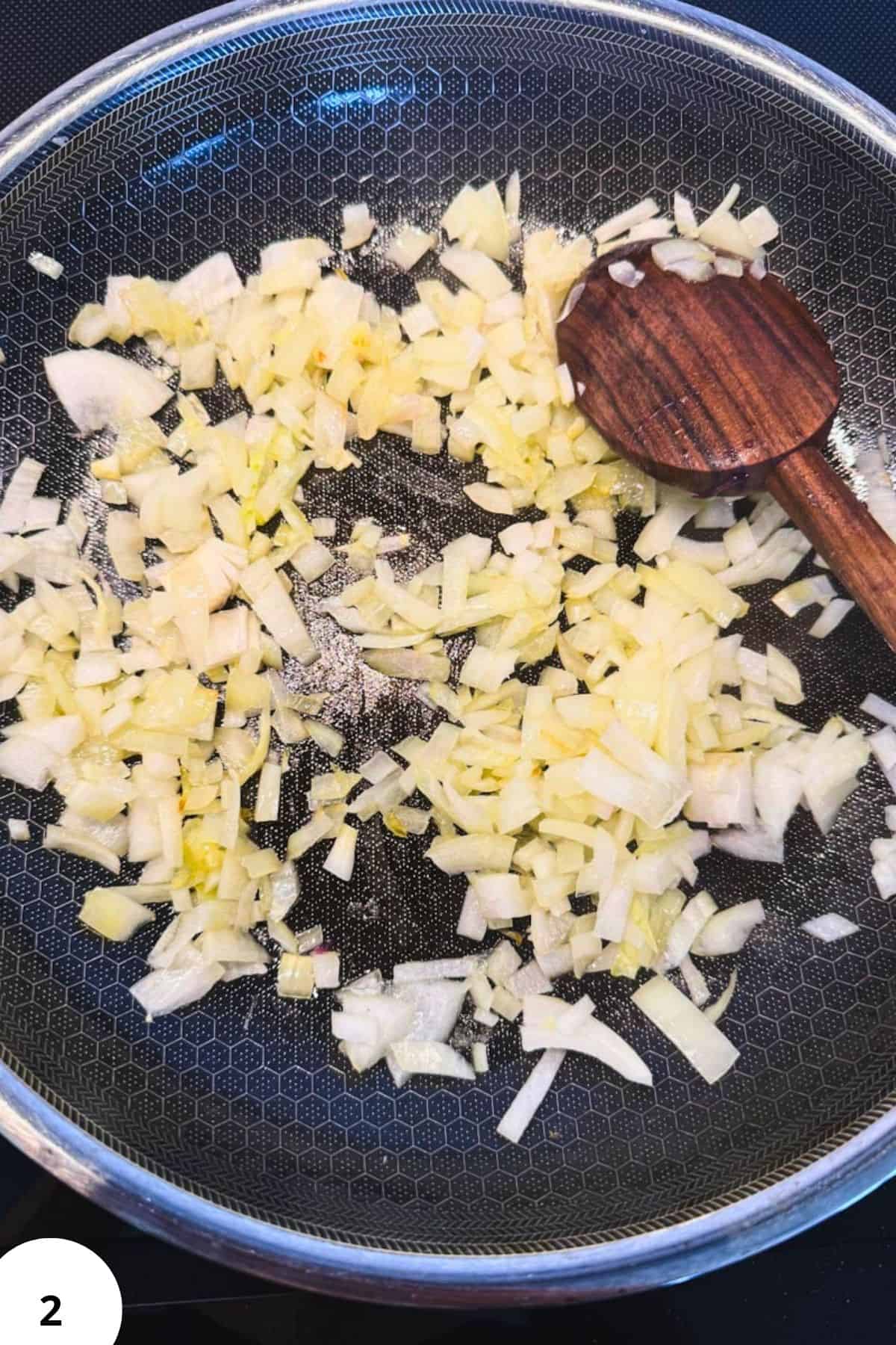 Sautéed onions in a non-stick pan for bread dough preparation.