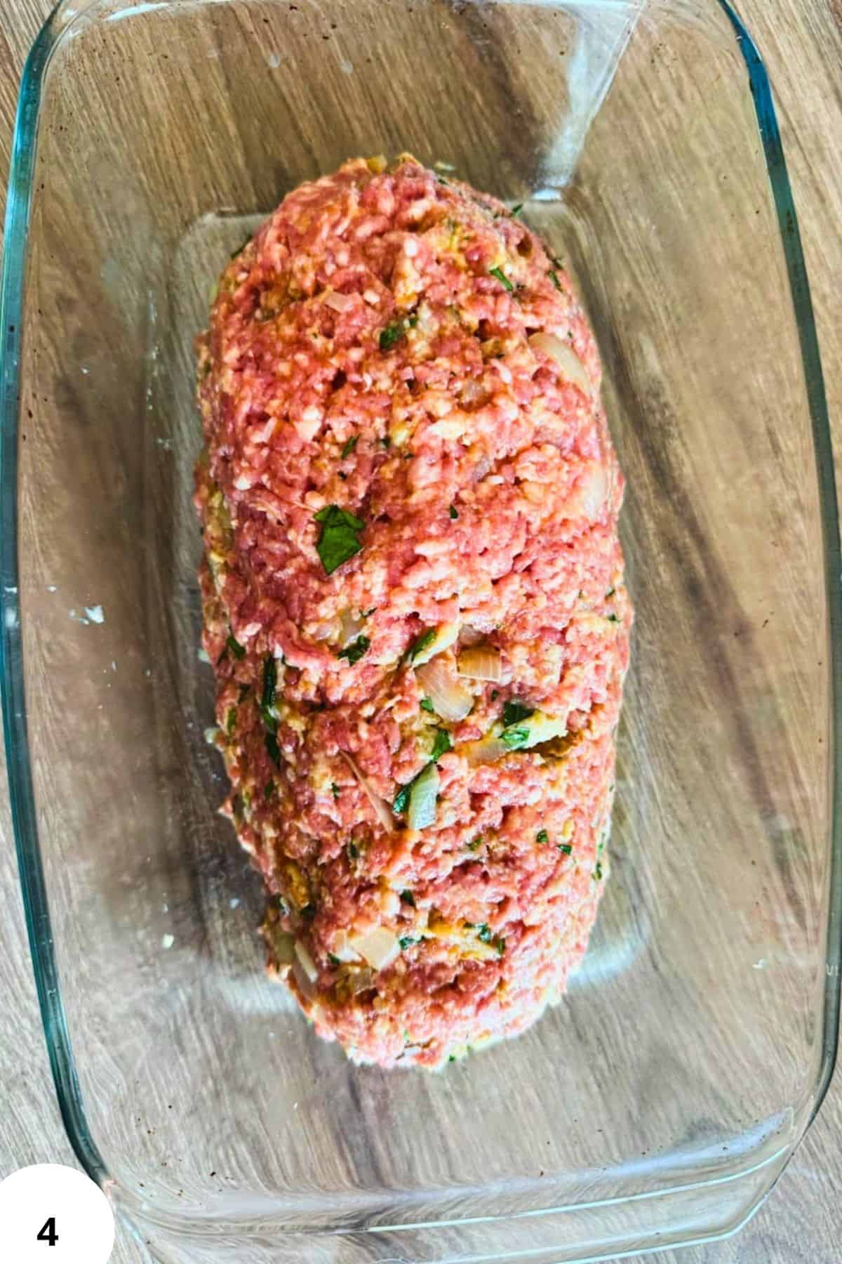 Classic German Hackbraten meatloaf with herbs in a glass baking dish.