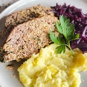 Delicious traditional German Hackbraten served with creamy mashed potatoes and flavorful red cabbage.