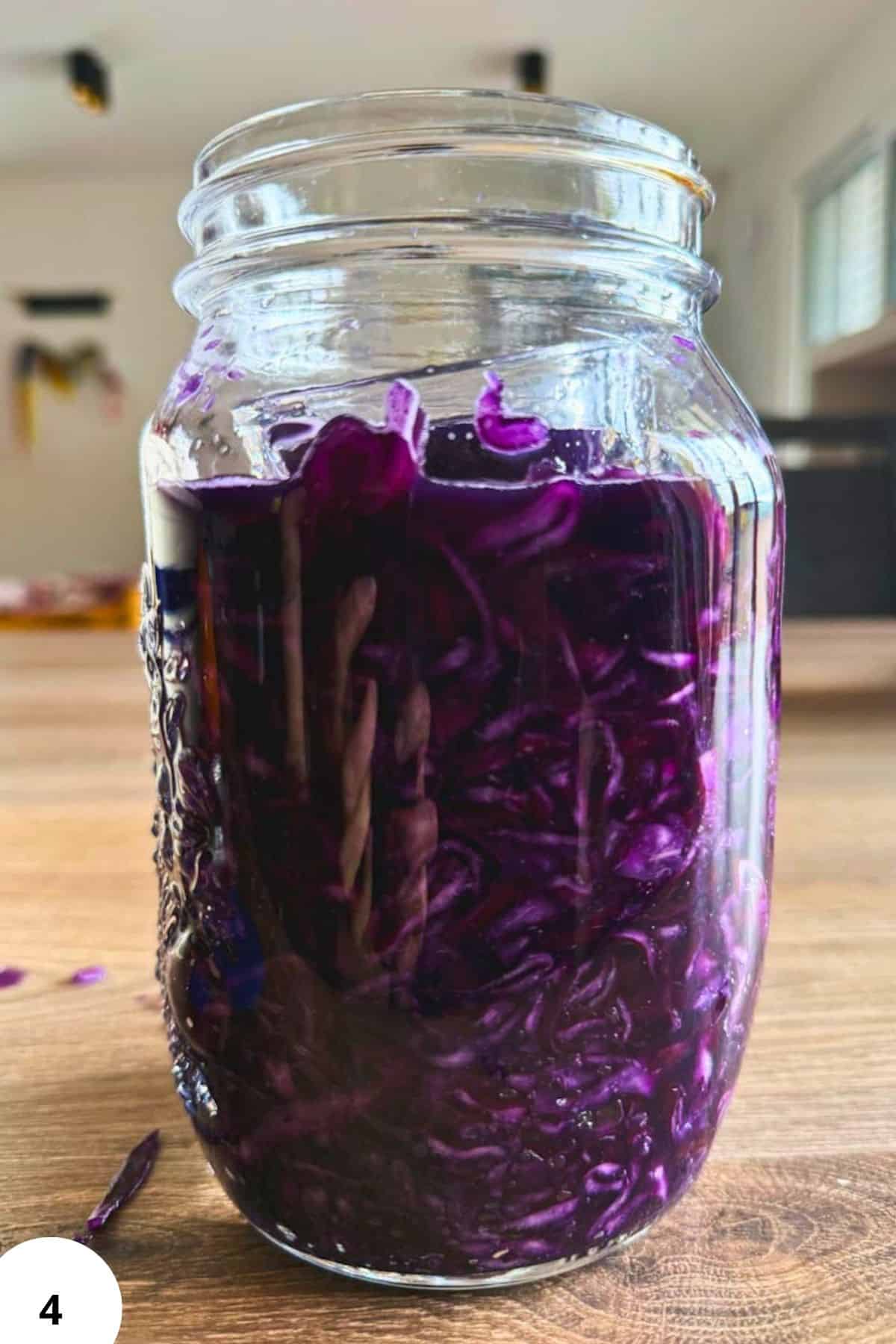 Jar of purple cabbage fermenting for pickling and preservation.