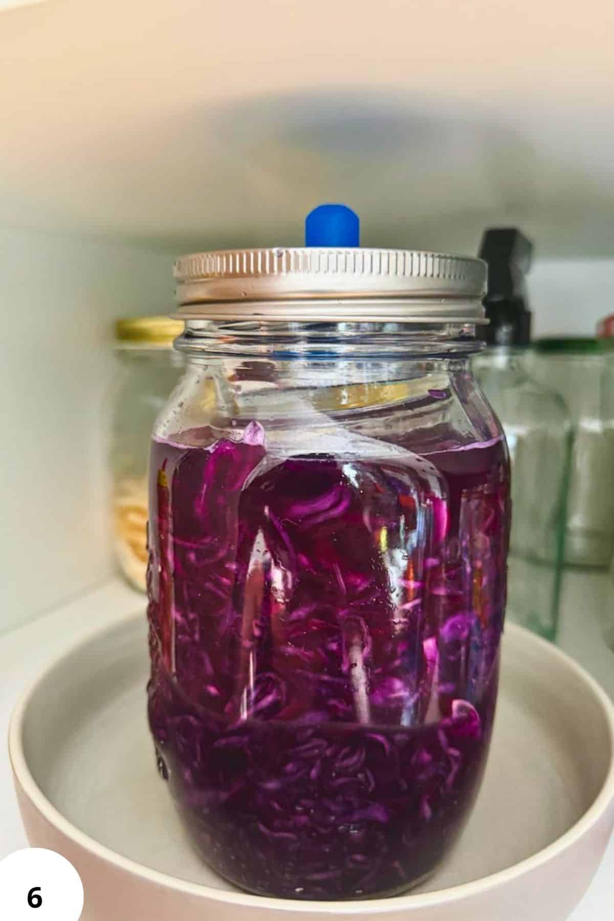 Colorful pickled vegetables in a glass jar for fermentation.