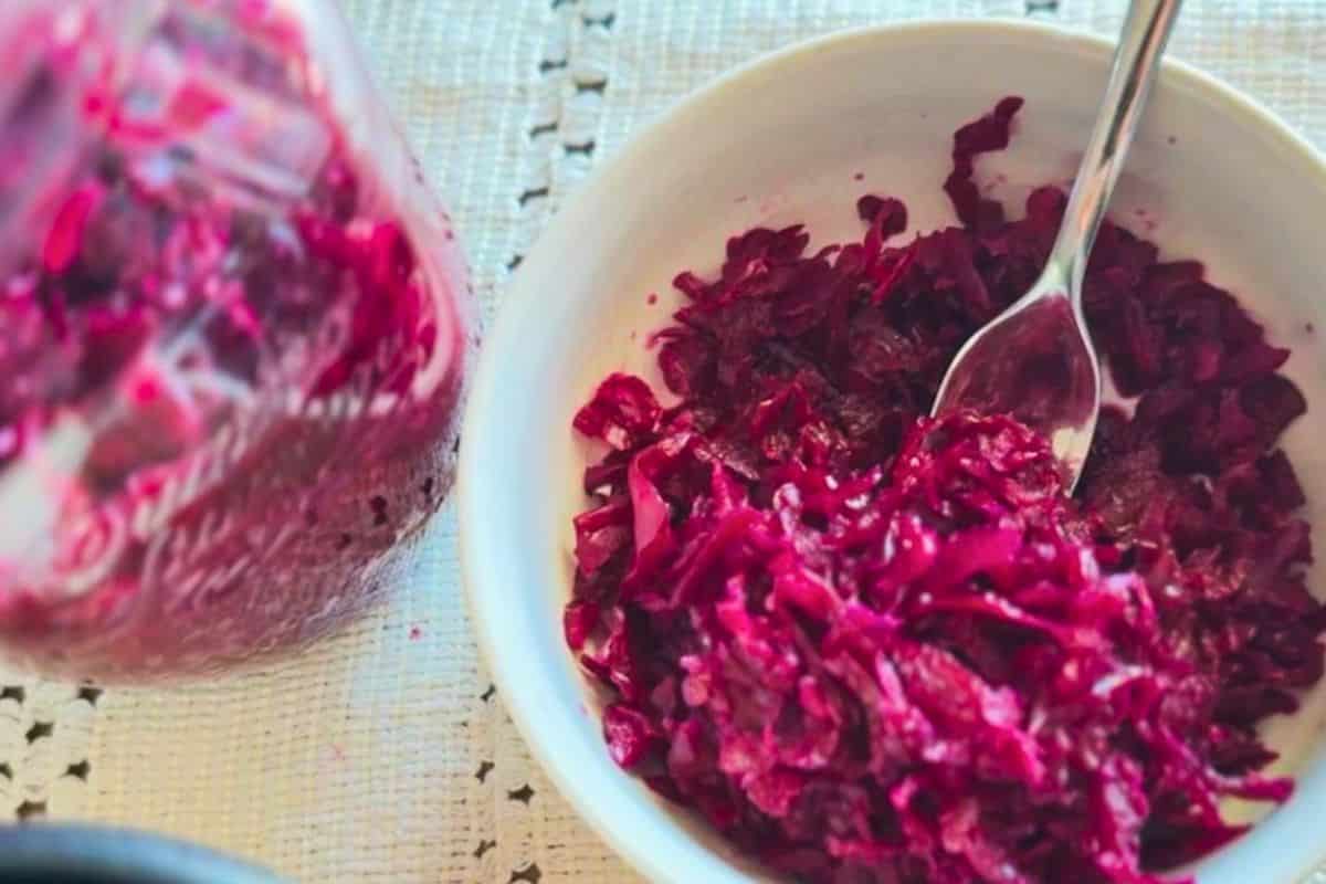 Fermented red cabbage in a white bowl, showcasing the fermentation process and vibrant color.