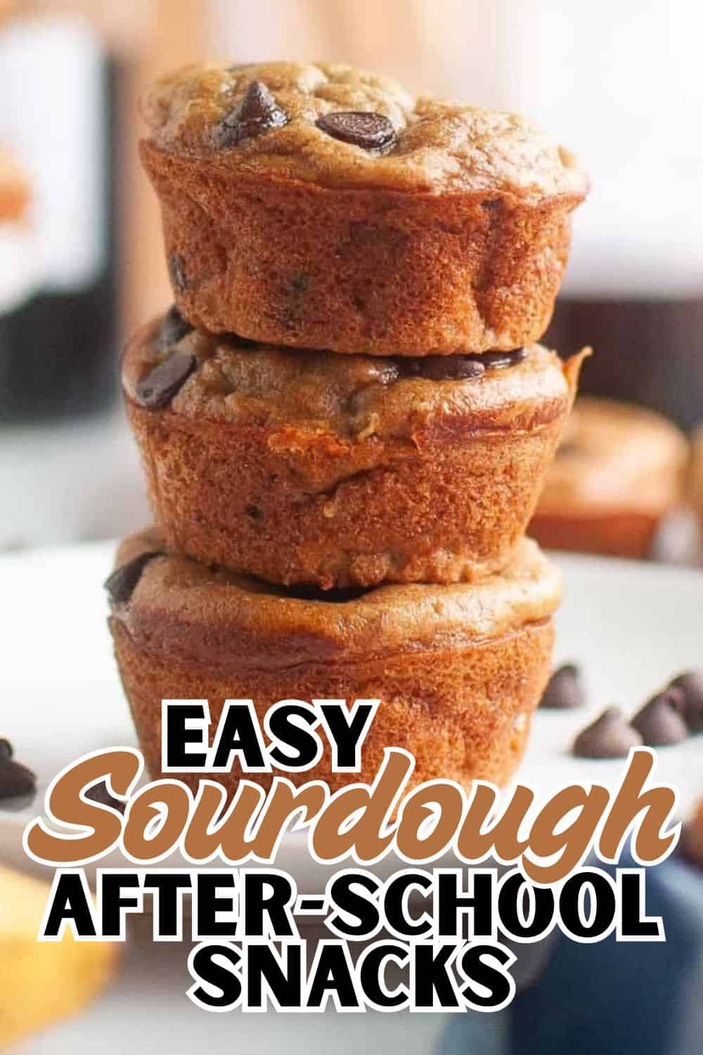 Freshly baked sourdough muffins stacked, showcasing their golden crust and chocolate chips.
