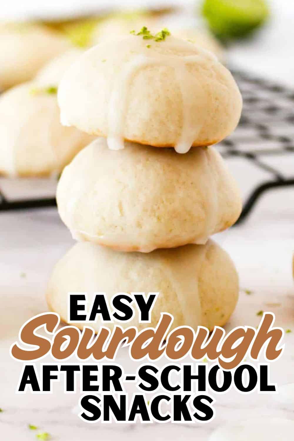 Close-up of soft, fluffy sourdough dinner rolls stacked on a wire rack.