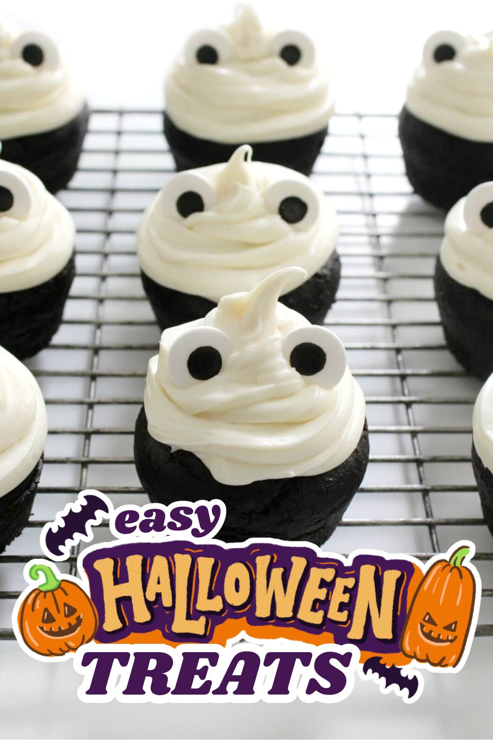 Halloween ghost cupcakes with white frosting and googly eyes on a cooling rack.