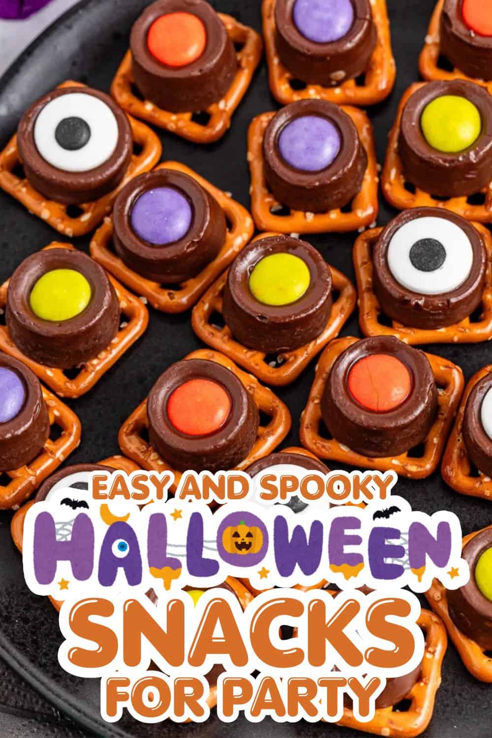 Halloween-themed snack bites with candy eyes, colorful toppings, and chocolate coating on a black tr.