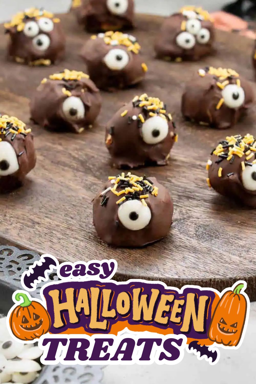 Chocolate Halloween treats decorated with eyeball candies and sprinkles on a wooden surface.