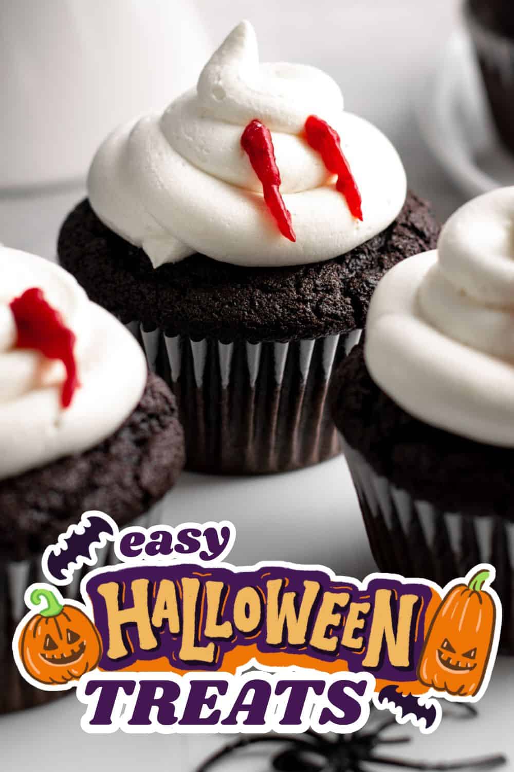 Chocolate cupcakes with white whipped topping and red drizzle for Halloween.