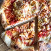 Close-up of Neapolitan-style sourdough pizza slices with cheese and toppings.