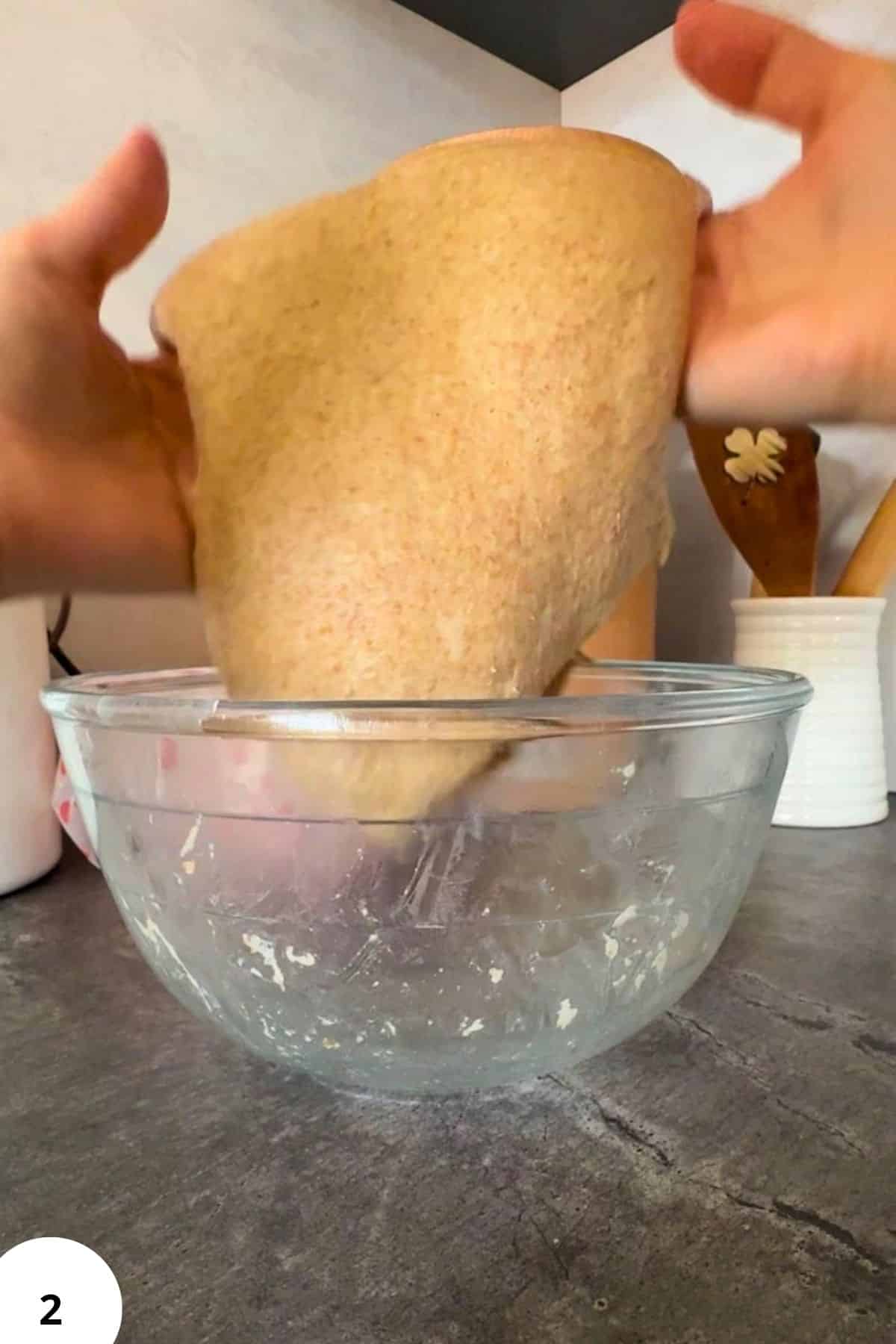 Freshly milled grain being ground into flour in a glass bowl.