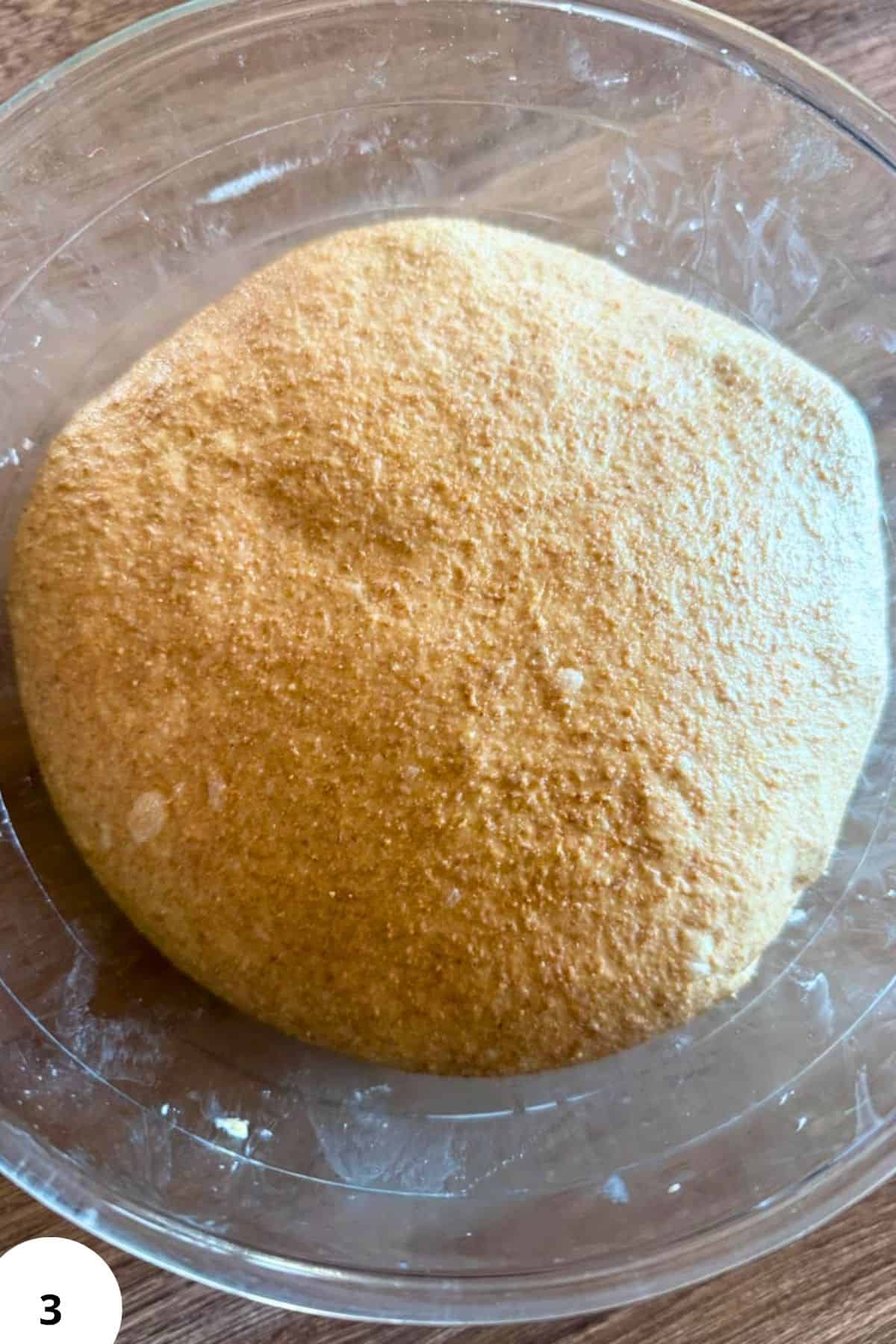Freshly milled grain flour in a glass bowl for baking and cooking.