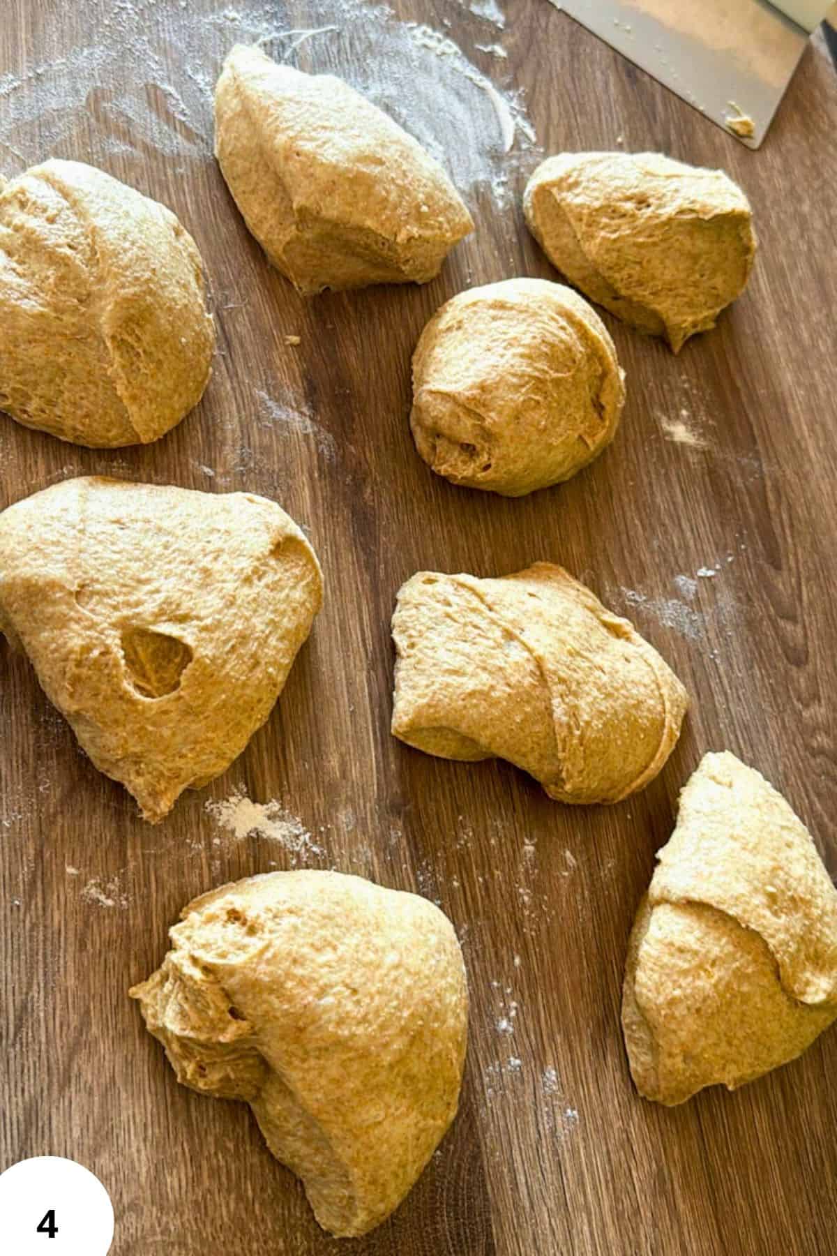 Freshly milled flour dough balls on a wooden surface for baking.