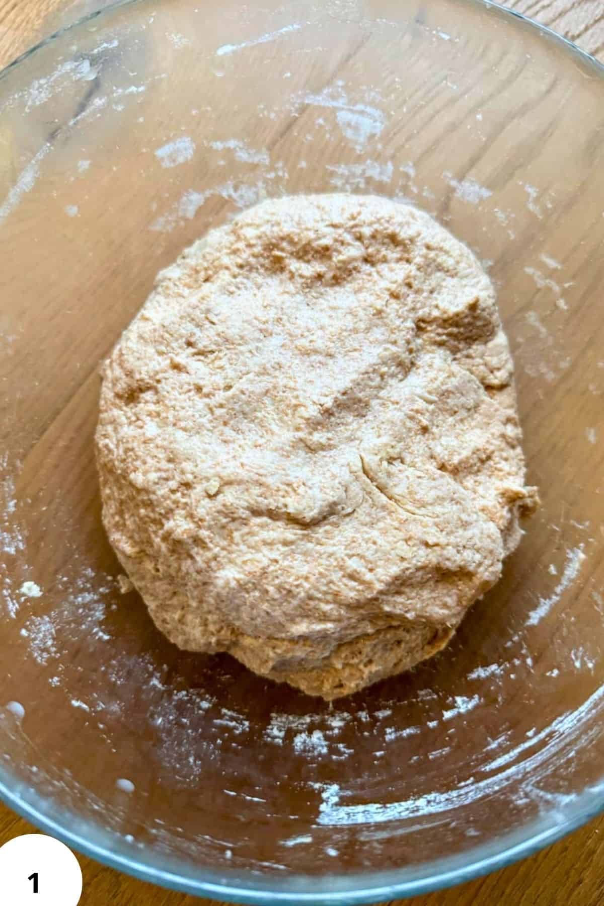 Freshly prepared whole grain flour dough in a glass bowl for baking recipes.