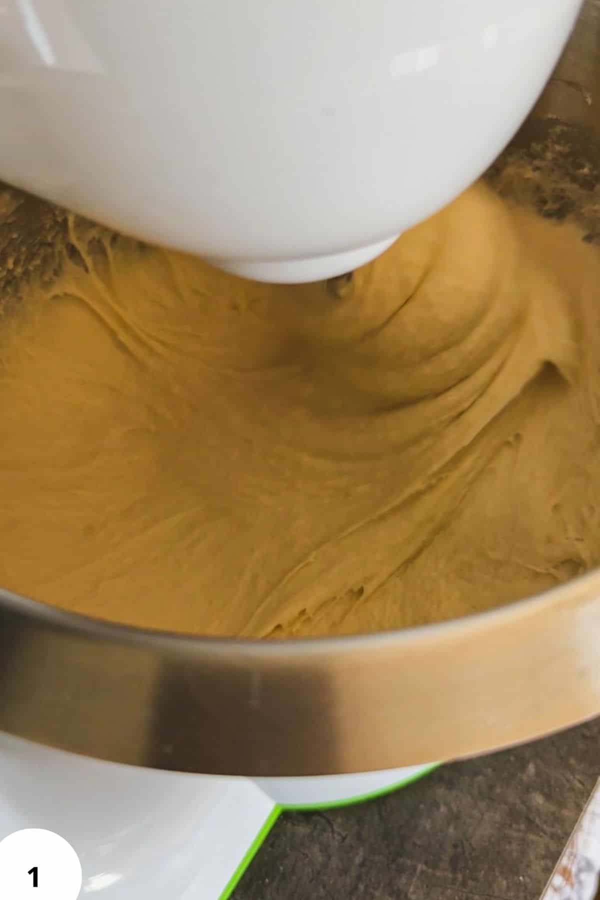 Dough being kneaded with stretch and fold technique in a stand mixer.