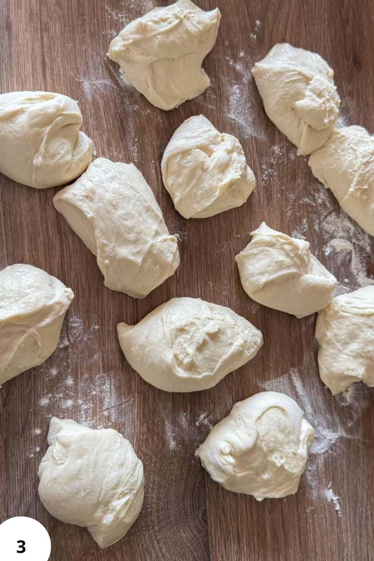 Dough balls prepared for stretch and fold technique on a wooden surface.
