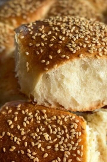 Freshly baked sesame seed buns with soft, fluffy interior and golden crust.