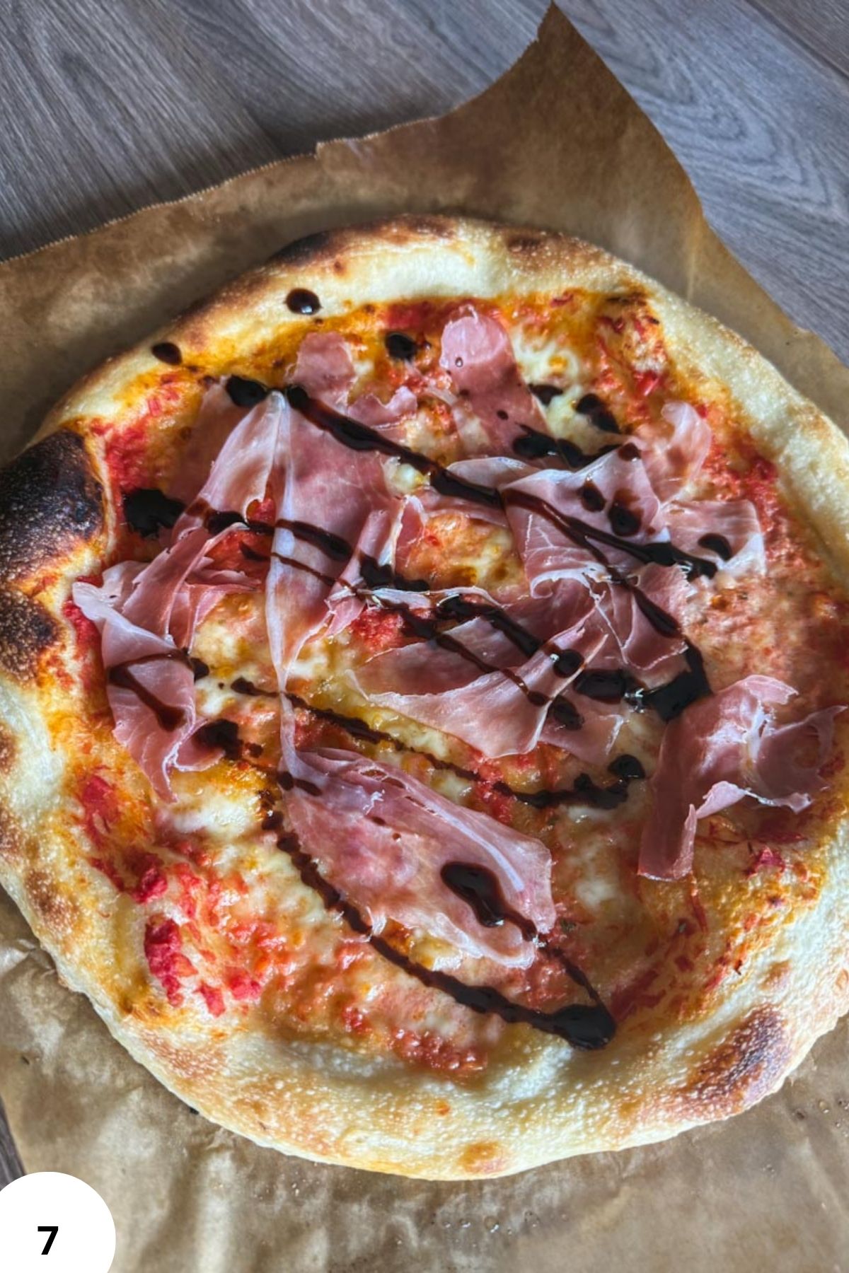 Close-up of sourdough pizza with ham, cheese, and chocolate drizzle.