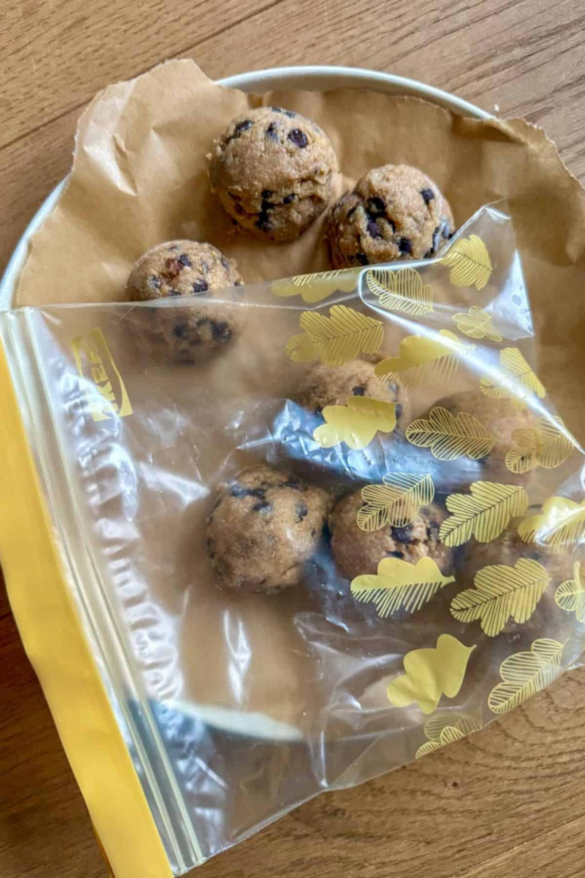 Chocolate chip cookies in a plastic bag on a wooden surface.
