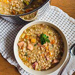 Hearty traditional Ričet stew with barley, beans, and smoked meat in a bowl.
