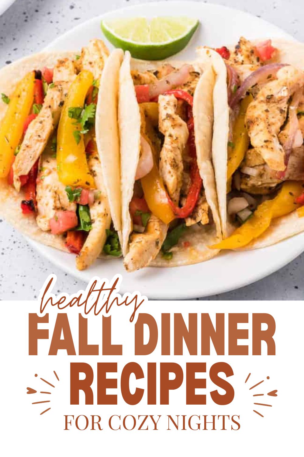 Three chicken tacos with colorful vegetables and lime wedge on white plate.